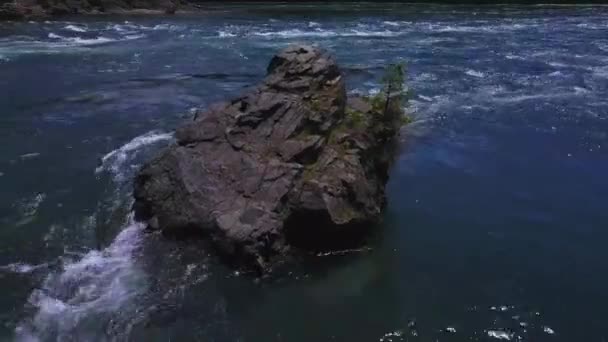 Stromend water met kleine rotsachtige eiland hieronder — Stockvideo