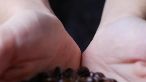 Женские руки держат кофейные зерна — стоковое видео