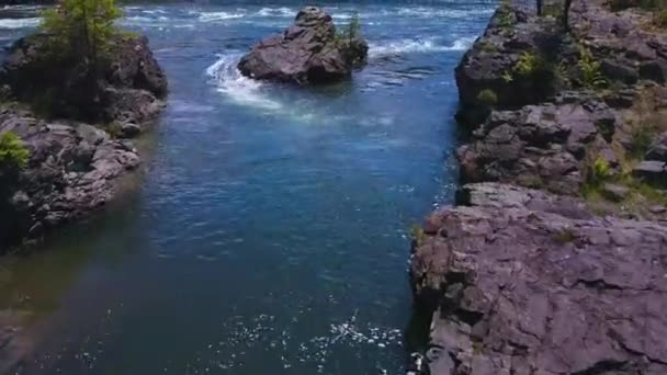 Stromend water met kleine rotsachtige eiland hieronder — Stockvideo