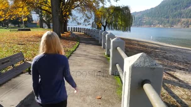 Kvinna Walkin längs vattnet — Stockvideo