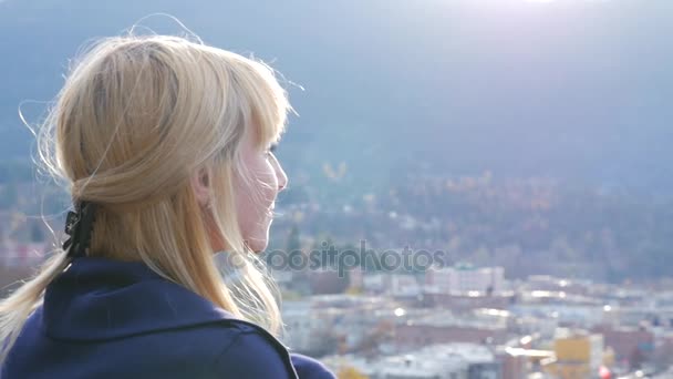 Mujer mirando hacia fuera sobre pequeño pueblo — Vídeos de Stock