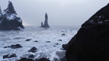 Bazalt kaya oluşumları görünümünü troller ayak siyah kum plaj, İzlanda 