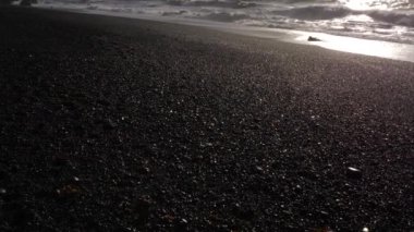 Siyah kum Beach görünümü ortaya bazalt kaya oluşumları troller ayak parmakları, İzlanda 