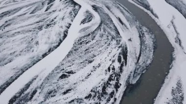 Kar hava görünümünü İzlanda dağlar ve akan nehir gündüz kaplı