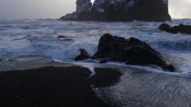 Bazalt kaya oluşumları görünümünü troller ayak siyah kum plaj, İzlanda 