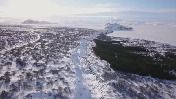在冰雪覆盖的冬季岩石山谷上空的无人驾驶飞机在白天 — 图库视频影像