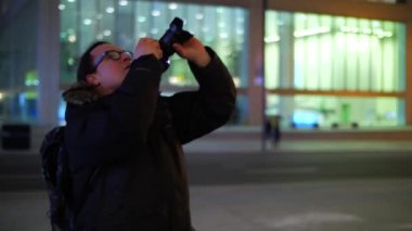 Uzun boylu şehir ofis binaları geceleri erkek fotoğrafçı alarak fotoğraf 