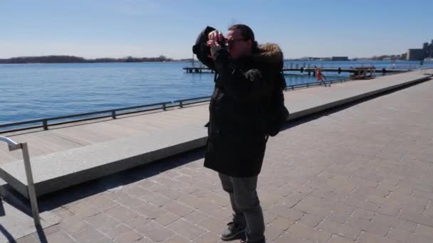 Manlig Fotograf Promenader Längs Waterfront Boardwalk Och Bilder Dagtid — Stockvideo