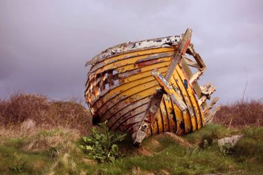 Kalan bir tepenin üzerinde terk edilmiş tekne geliyor.
