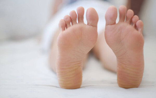 Woman feet on the bed