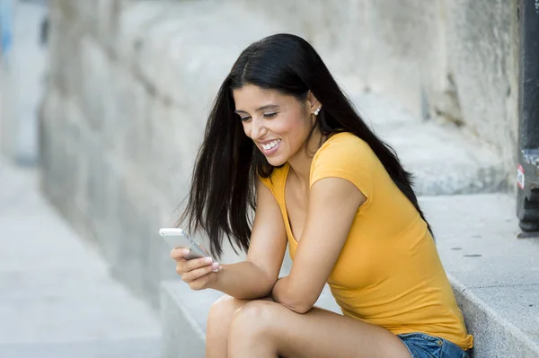 Девушка улыбается смс на смартфоне — стоковое фото