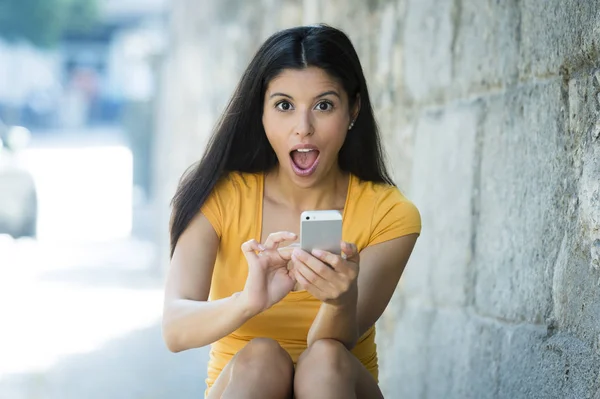 Шокированная женщина держит смартфон — стоковое фото