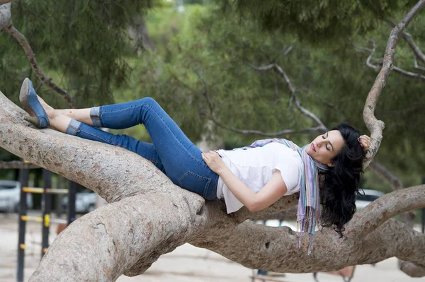 Женщина позирует лежащей на дереве — стоковое фото