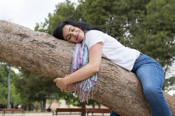Pretty woman hugging tree