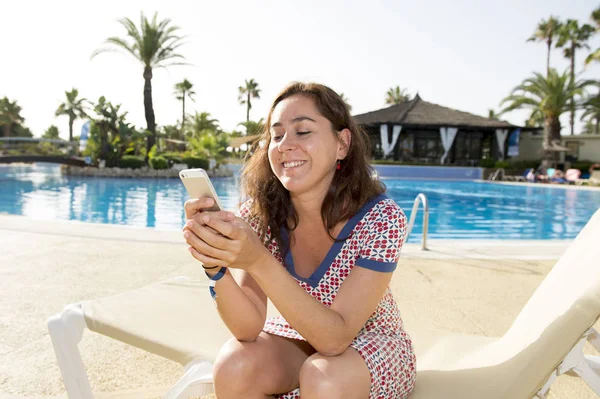 Atractiva mujer mensajes de texto por la piscina — Foto de Stock