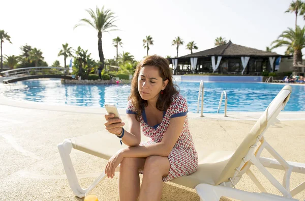 Attraktiv kvinna med telefon av poolen — Stockfoto