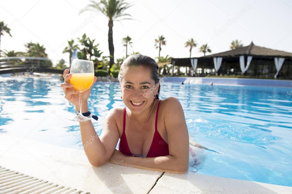 Woman by the pool with drink in a glass