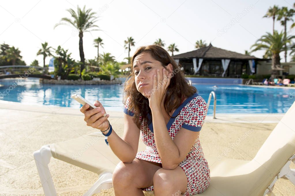 Attractive woman with phone by pool