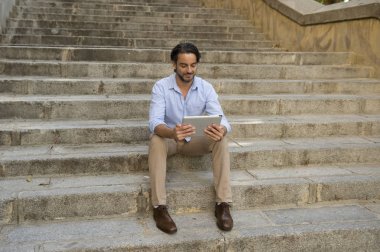 Adam şehir merdiven üzerinde tablet kullanma