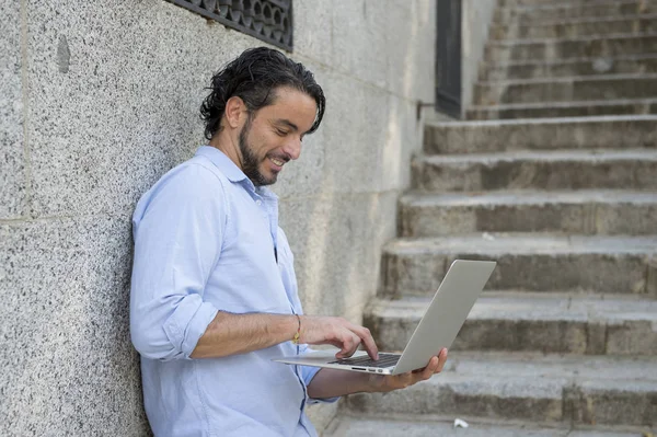 Hombre en la escalera de la ciudad trabajando con el ordenador portátil — Foto de Stock
