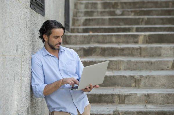 Hombre en la escalera de la ciudad trabajando con el ordenador portátil — Foto de Stock