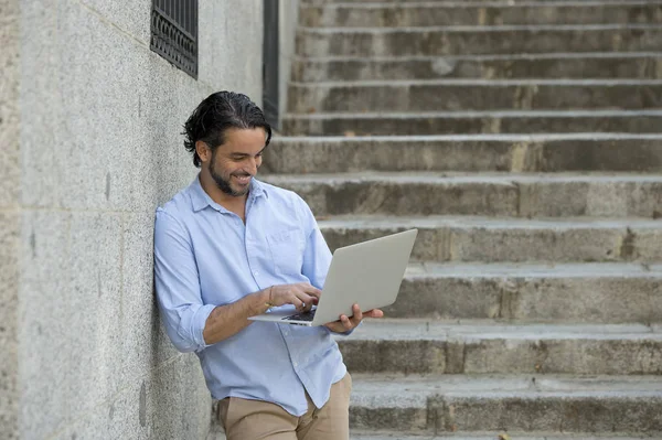 Человек на городской лестнице работает с ноутбуком — стоковое фото