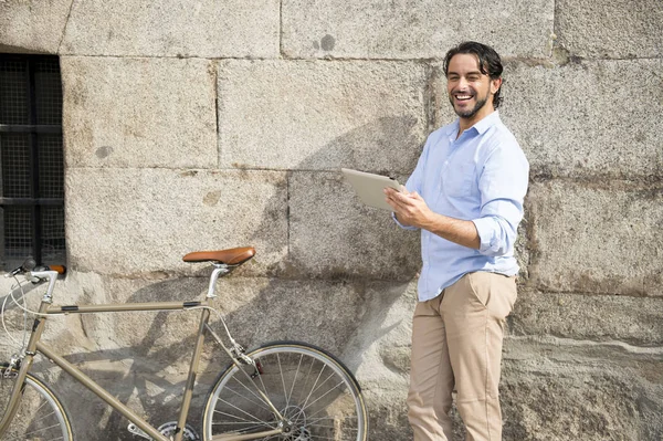 man with vintage bicycle using tablet