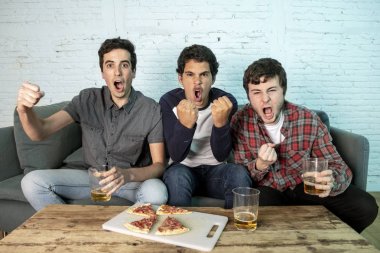 Grup genç futbol hayranları kanepe izlerken futbol oyun ve içki bira üzerinde oturan heyecanlı