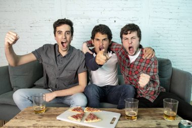 Grup genç futbol hayranları kanepe izlerken futbol oyun ve içki bira üzerinde oturan heyecanlı