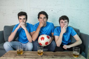 Mavi t-shirt futbol oyunu evde kanepede izlerken hayal kırıklığı genç futbol hayranları grup