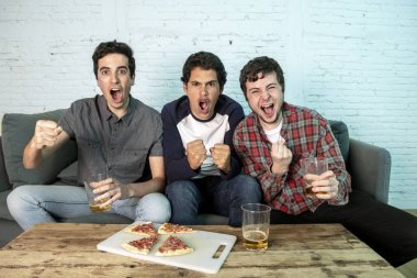 Grup genç futbol hayranları kanepe izlerken futbol oyun ve içki bira üzerinde oturan heyecanlı