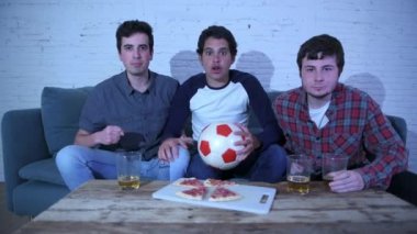 bir futbol maçı izlerken kanepede oturan futbol hayranları mutlu ve heyecanlı genç grup