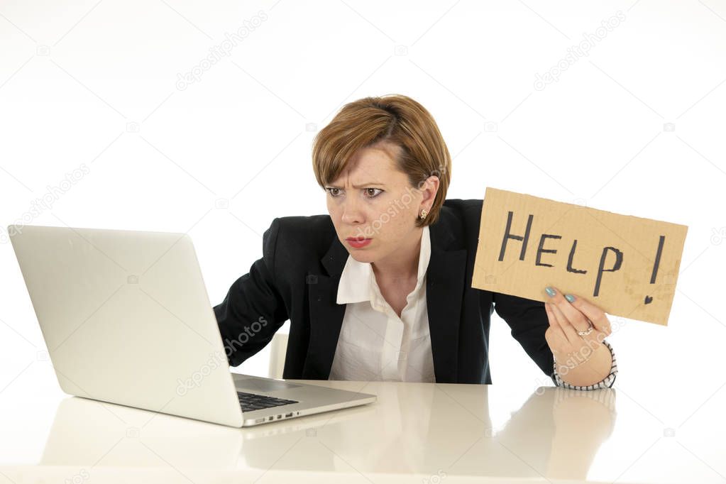 beautiful young red haired caucasian tired and frustrated business woman working on her computer holding a help sign at work office desk on a white background.Stress and business frustration concept