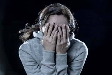 korku, utanç, şiddet ve depresyon kavramı. Çekici latin depresif kadın izole siyah arka plan üzerinde elleriyle yüzünü kapsar