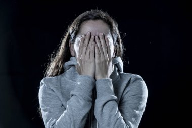 korku, utanç, şiddet ve depresyon kavramı. Çekici latin depresif kadın izole siyah arka plan üzerinde elleriyle yüzünü kapsar