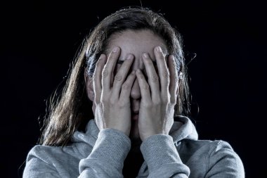 korku, utanç, şiddet ve depresyon kavramı. Çekici latin depresif kadın izole siyah arka plan üzerinde elleriyle yüzünü kapsar
