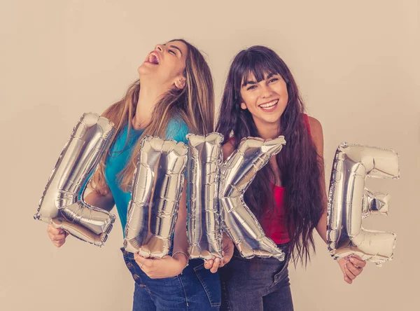 Дві Вродливі Молоді Жінки Тримають Повітряні Кулі Утворюють Текст Щаслива — стокове фото