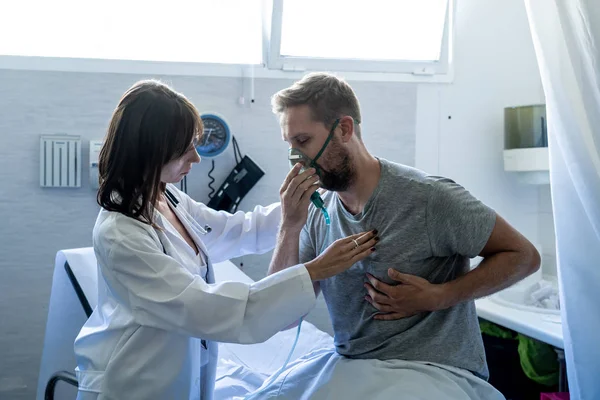 Ung Sjuk Man Patient Med Syrgasmask Medan Kvinnlig Läkare Lyssnar — Stockfoto