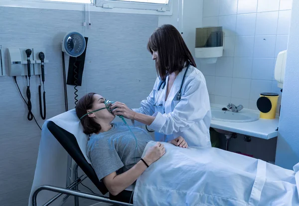 Ärztin Mit Junger Kranker Patientin Mit Sauerstoffmaske Die Vor Schmerz — Stockfoto