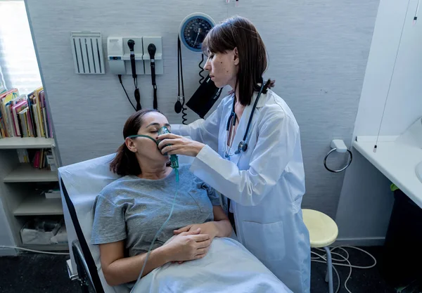 Vrouwelijke Arts Met Jonge Zieke Vrouw Patiënt Met Zuurstofmasker Kijken — Stockfoto