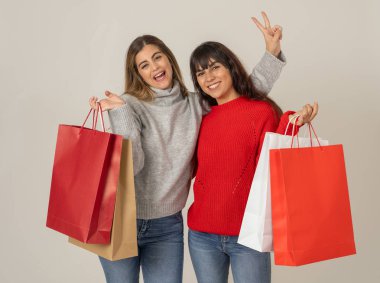 Alışveriş poşetleri taşıyan heyecanlı gençler, cuma ya da sezon satışlarından alışveriş yapıyorlar. Alışveriş gününden sonra ellerinde renkli çantalar olan mutlu ve neşeli arkadaşlar. Moda ve mağaza bağımlılığı.