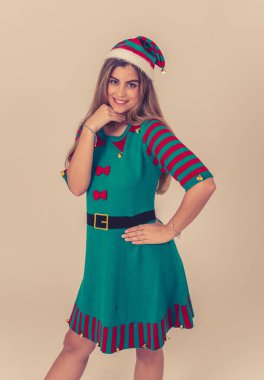 Mutlu Noeller ve iyi tatiller. Çekici, neşeli genç kadın elf elbisesi içinde seksi, sevimli ve komik görünüyor. Reklam tarzı Noel kutlaması stüdyo resmi.