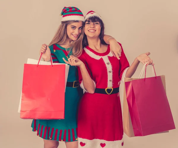 兴奋的年轻人拿着购物袋买圣诞礼物 戴着圣诞礼帽 穿着可笑的圣诞服装 带有文本复制空间的纸袋 圣诞购物和黑色星期五 — 图库照片