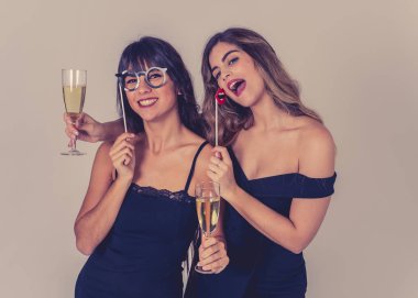 Noel 'i kutlayan iki güzel kız arkadaş ya da kadeh kaldıran yeni yıl arifesi. Şık, seksi parti elbiseleriyle poz veren kadınlar şampanya içiyor. Halkın Dostluğu ve Kutlaması.