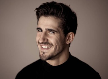 Yakışıklı, yakışıklı bir adamın portresi. Seksi ve şehvetli görünüyor. Güzel siyah evetler ve saçlar. İspanyol erkeksi pozunun stüdyo çekimi. Moda, doğal güzellik, modellik ve yaşam tarzı..