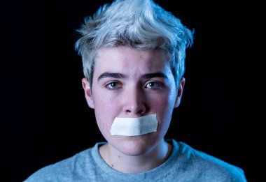 Sansürün kavramsal görüntüsü ve cinsiyet çeşitliliği kavramının sosyal tabusu. Ağzı bantlanmış, iletişim kuramayan ya da kendi kimliğini ifade edemeyen transseksüel genç..