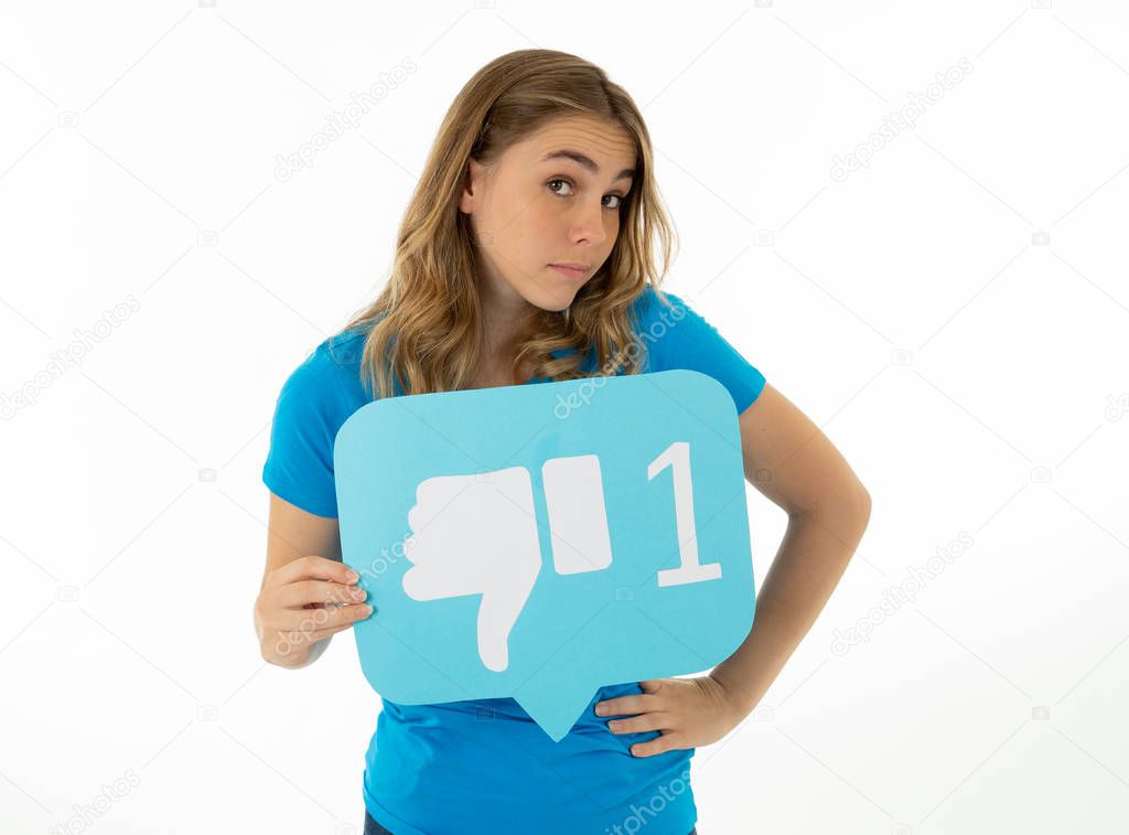 Attractive unhappy young woman holding social media symbol of dislike feeling sad and rejected in internet obsession, social network notification icons, cyber bullying and technology communication.