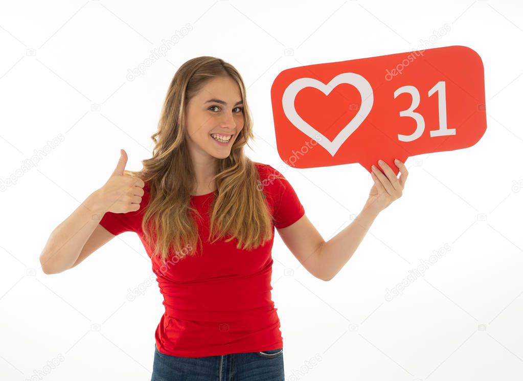 Attractive woman holding heart symbol of like and love social media notification icon happy with followers and fans on the internet. Girl loving having likes In social media obsession and networking.