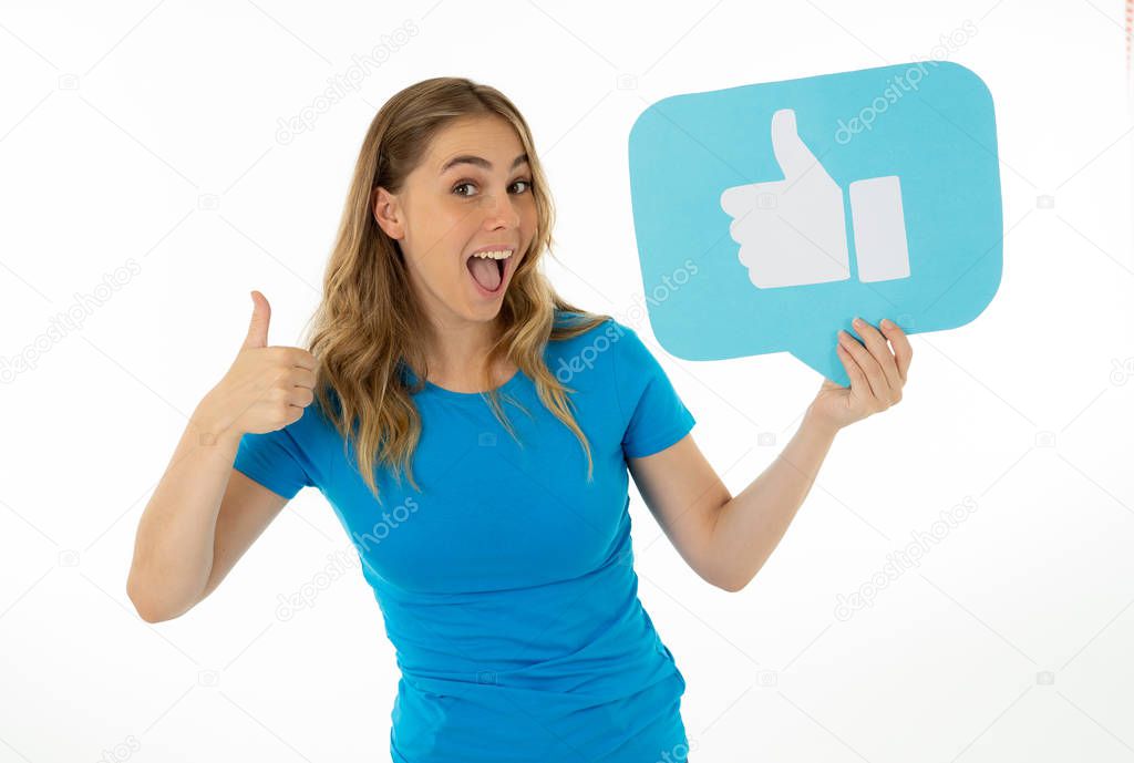 Beautiful young woman holding Like symbol social media notification icon asking followers to like her online comments, blog or business. In Internet obsession, networking and technology connections.