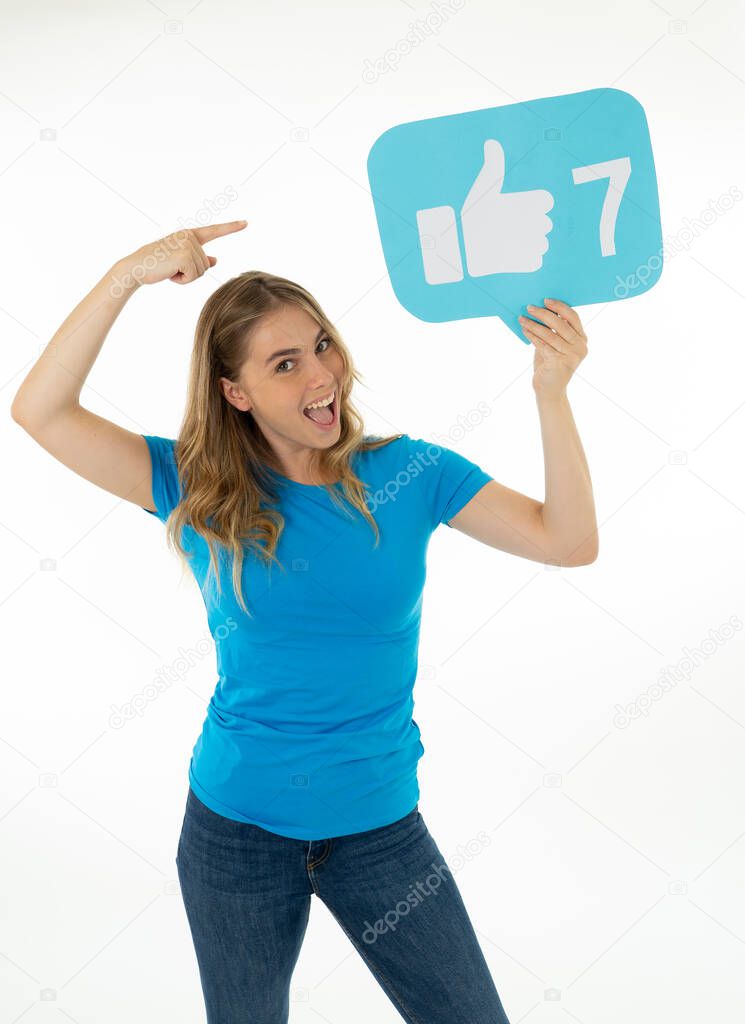 Beautiful young woman holding Like symbol social media notification icon asking followers to like her online comments, blog or business. In Internet obsession, networking and technology connections.